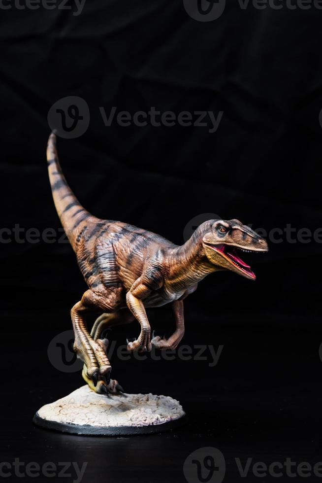 de velociraptor dinosaurie i de mörk foto
