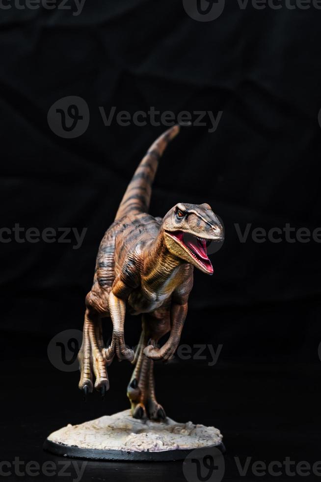 de velociraptor dinosaurie i de mörk foto