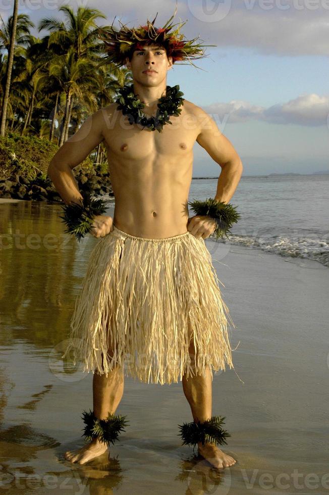 hawaiian manlig hula dansare med en kraft utgör på solnedgång förbi de strand. foto
