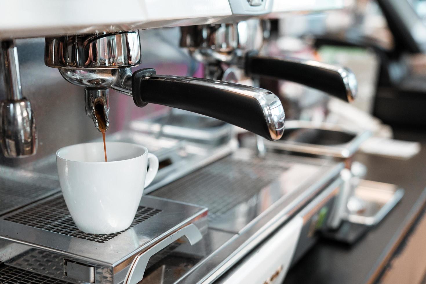 svart espresso droppar från kaffebryggaren foto