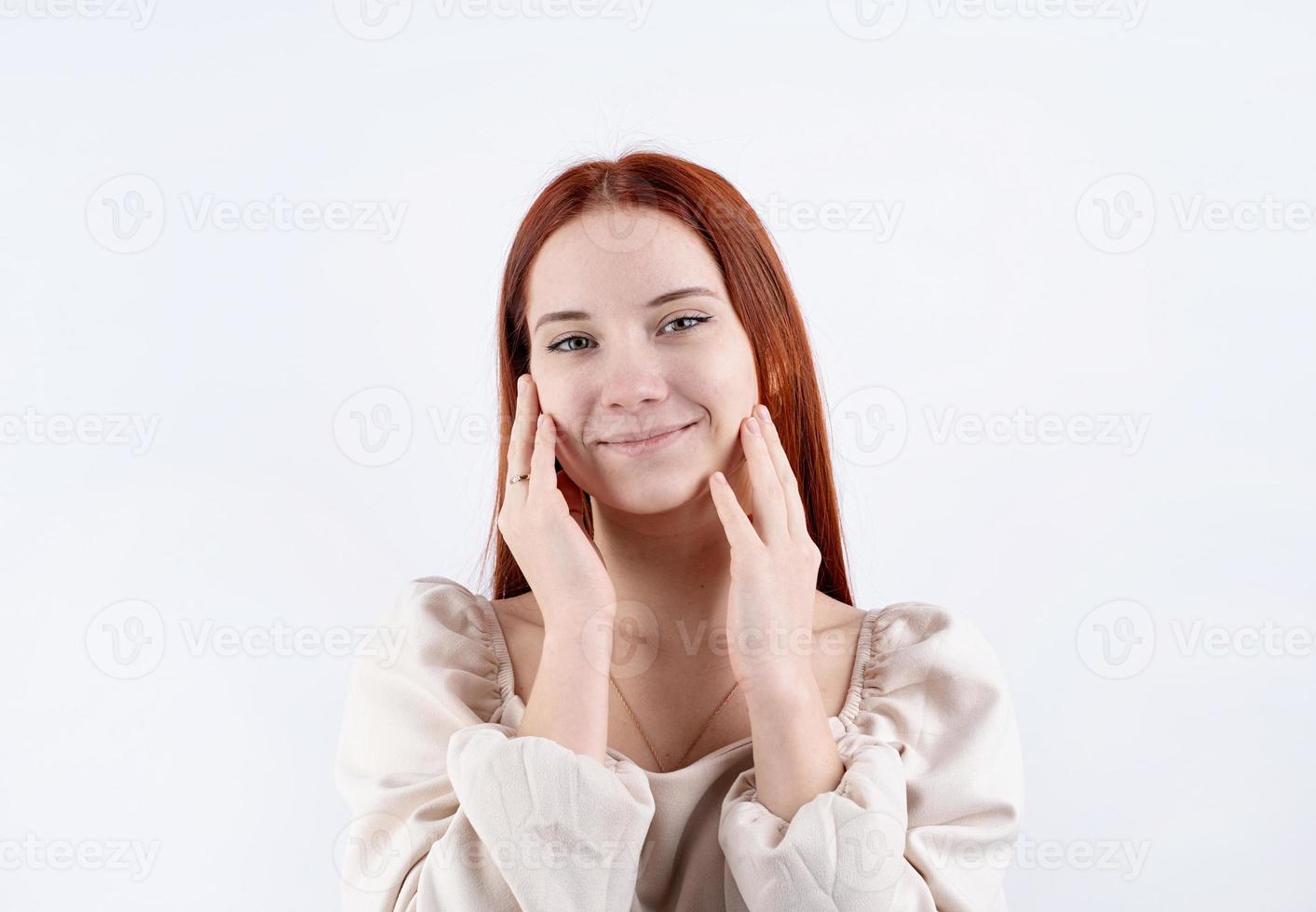 porträtt av en ung skön kvinna rörande henne ansikte på vit bakgrund, kopia Plats foto