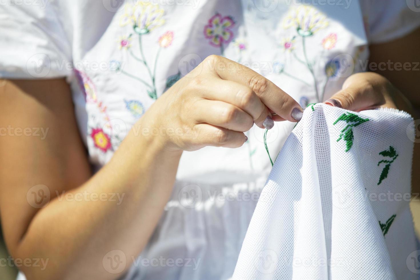 händer är broderad med en korsa. handarbete och folk konst. foto