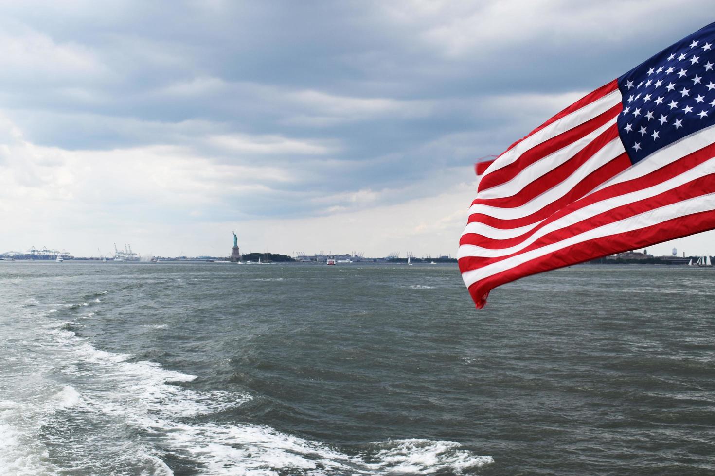 amerikansk flagga med frihetsstatyn i bakgrunden foto