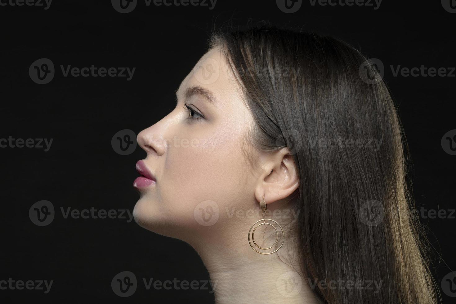 profil av en ung kvinna modell med perfekt sensuell mun och stängd ögon på en svart bakgrund. skön ansiktsbehandling hud, förstärkning av kvinna mun, glamorös elegans. foto