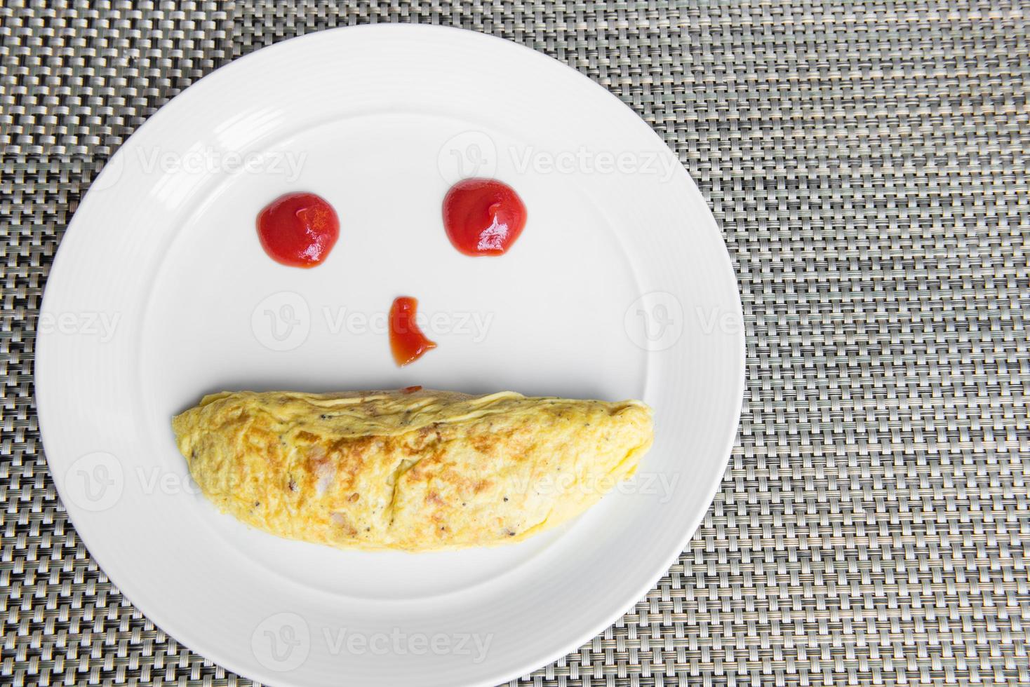 gul omlette serverar med ketchup på vit tallrik foto