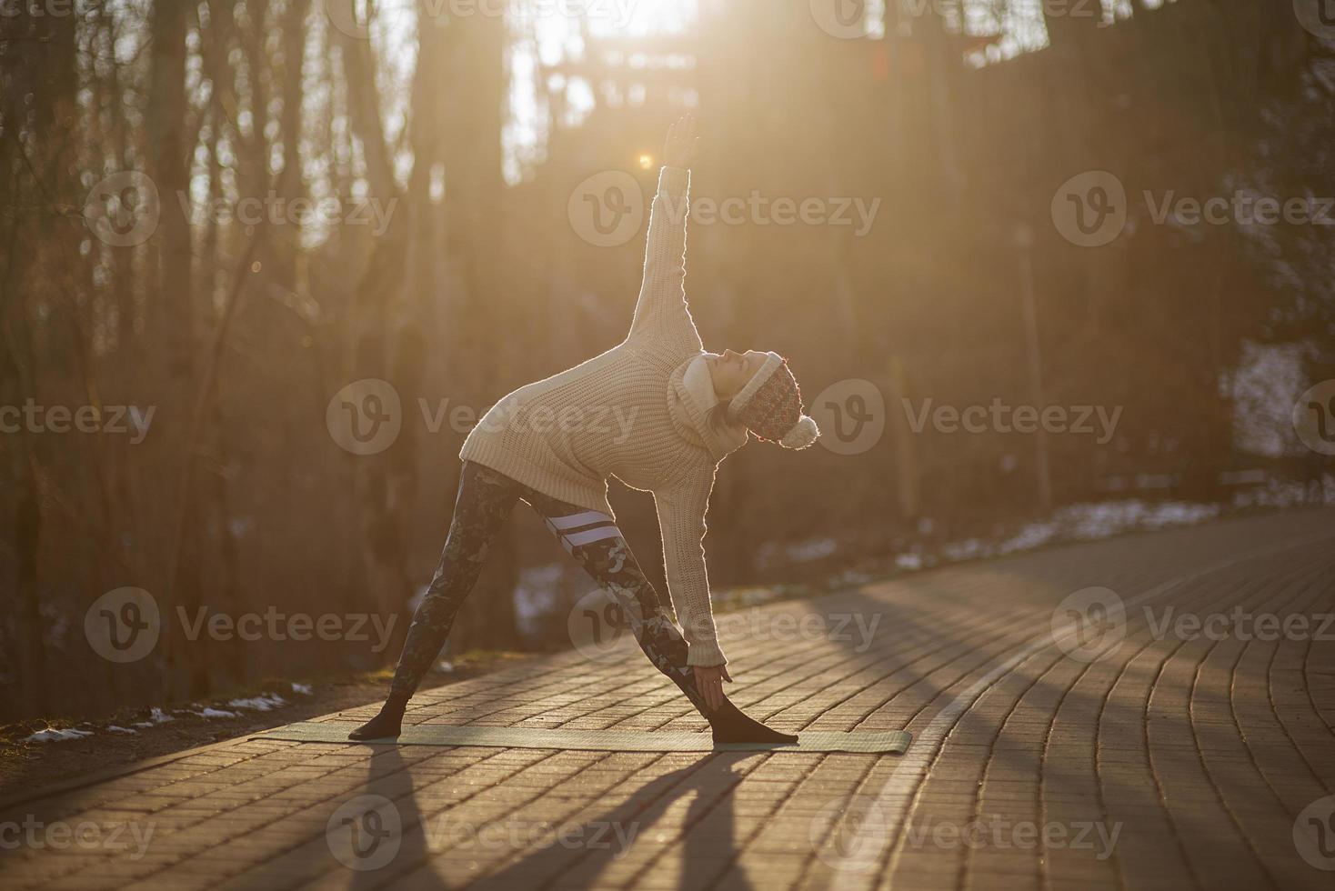 en ung atletisk kvinna utför yoga- och meditationsövningar utomhus foto