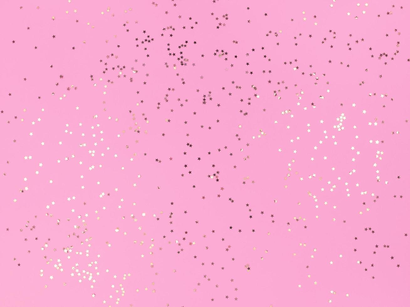 konfettistjärnor mousserande på en rosa bakgrund foto