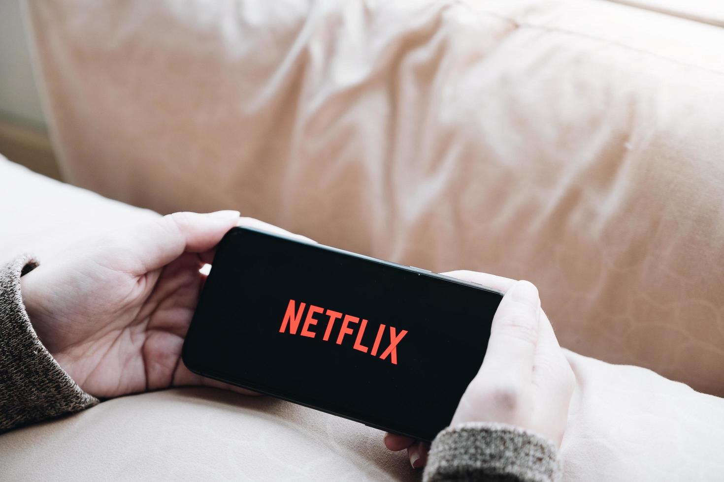 Chiang Mai, Thailand, 21 mars 2021 - person som tittar på Netflix på telefon foto