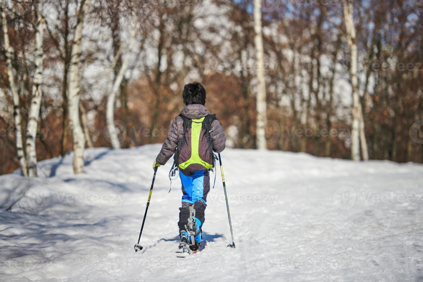 pojke med touring skidor i snöig väg foto