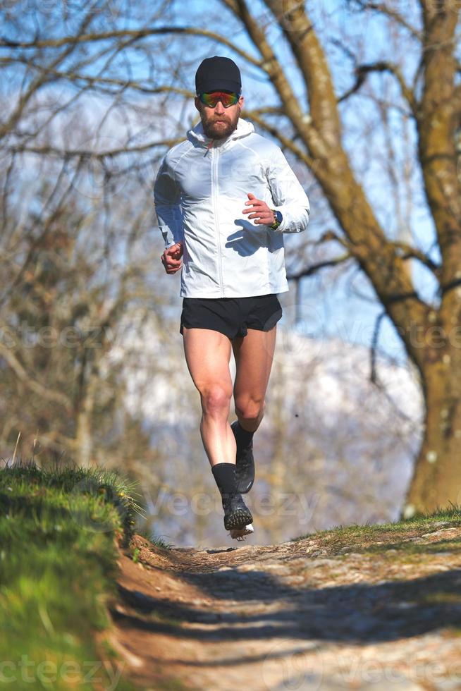 man springer på en bergspår foto