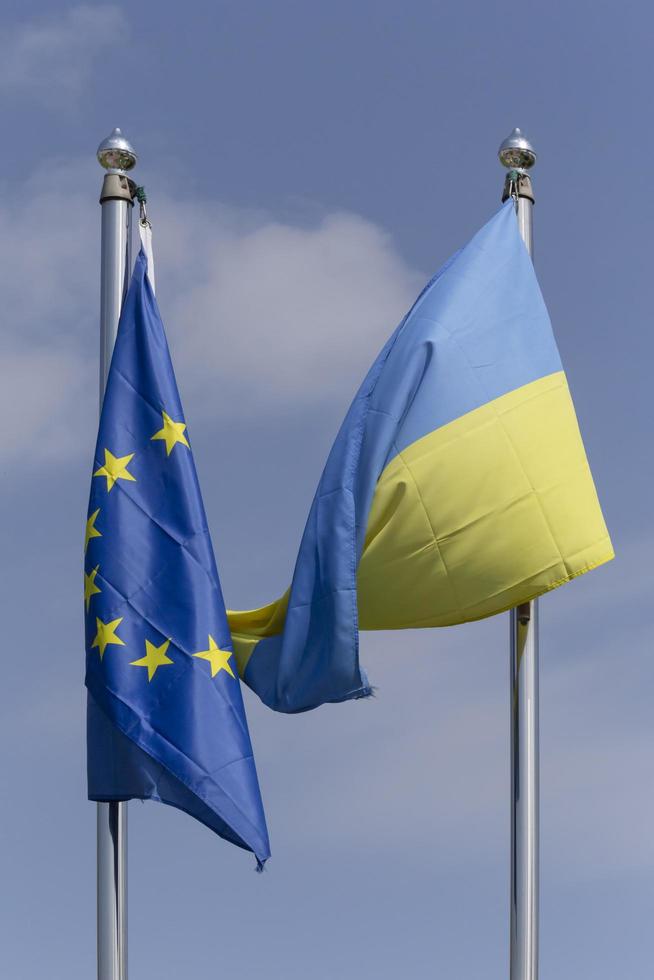 europeisk union och ukrainska flaggor hängande på flaggstänger foto