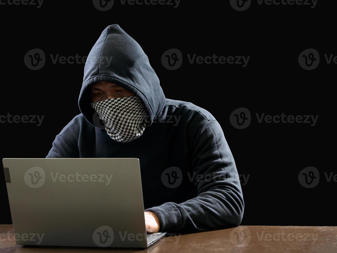 hacker spionera man ett person i svart luvtröja Sammanträde på en tabell ser dator bärbar dator Begagnade logga in Lösenord ge sig på säkerhet till cirkulera data digital i internet nätverk systemet, natt mörk bakgrund. foto