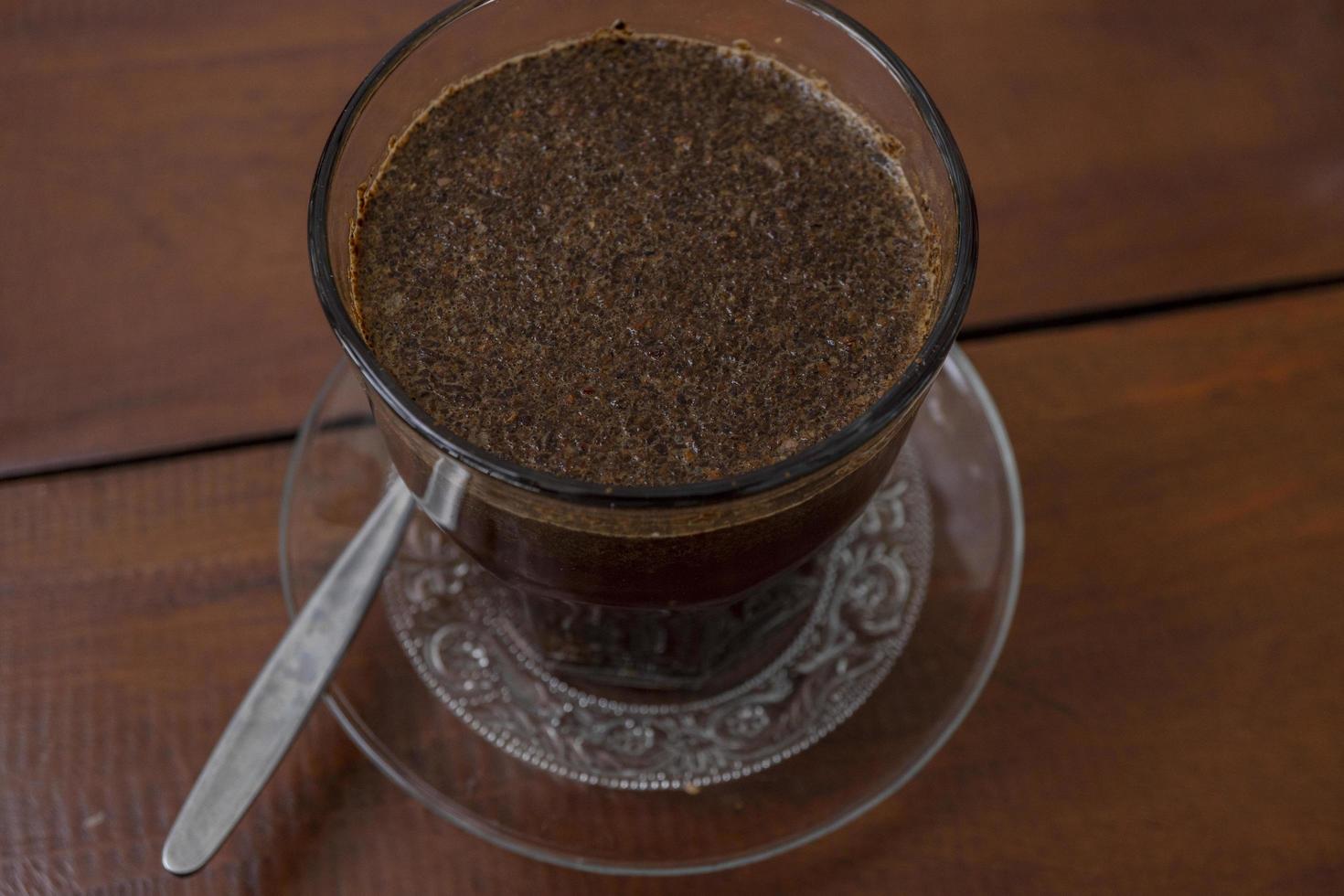 stänga upp Foto en kopp av arabica kaffe med sked från hög vinkel. de Foto är lämplig till använda sig av för kaffe affär bakgrund, meny affisch och kaffe innehåll media.