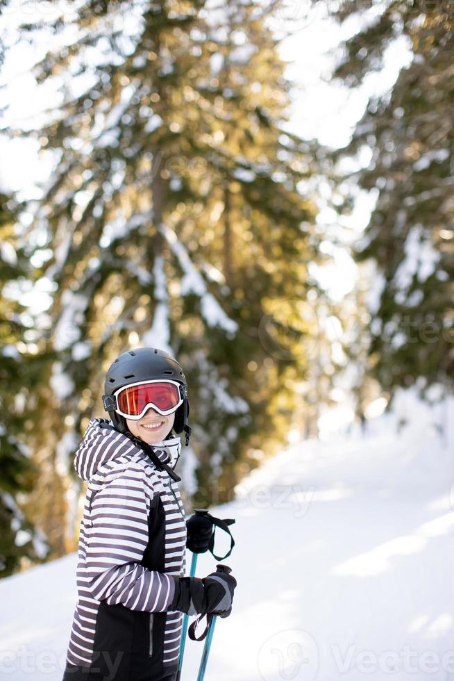 ung kvinna enjoing vinter- dag av skidåkning roligt i de snö foto