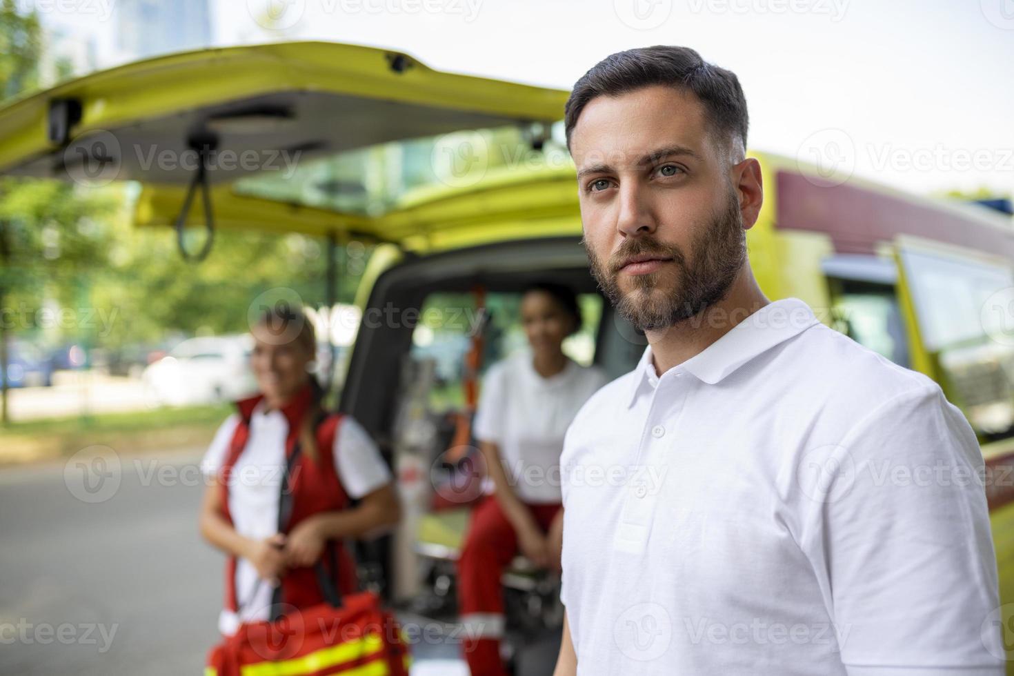 para sjuksköterska och nödsituation läkare på ambulans med utrustning. en sjukvårdare, stående på de bak- av ett ambulans, förbi de öppen dörrar. foto