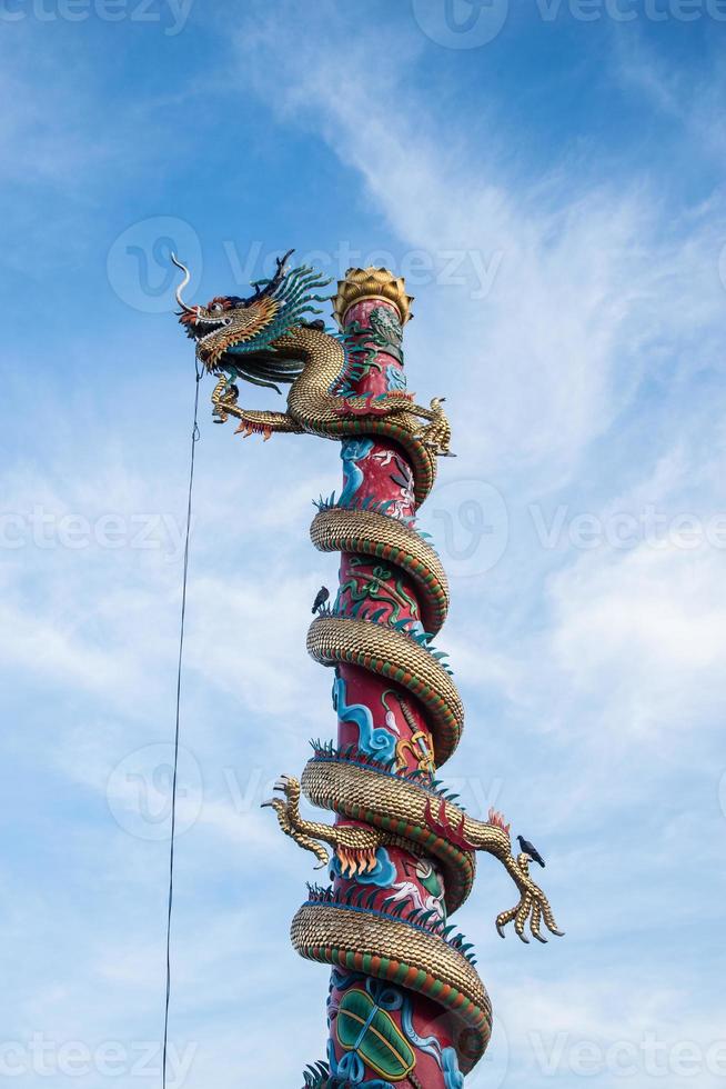 färgrik kinesisk drake staty vrida de pelare eller Pol på wat sangkat rattana khiri i thailand på blå himmel bakgrund foto