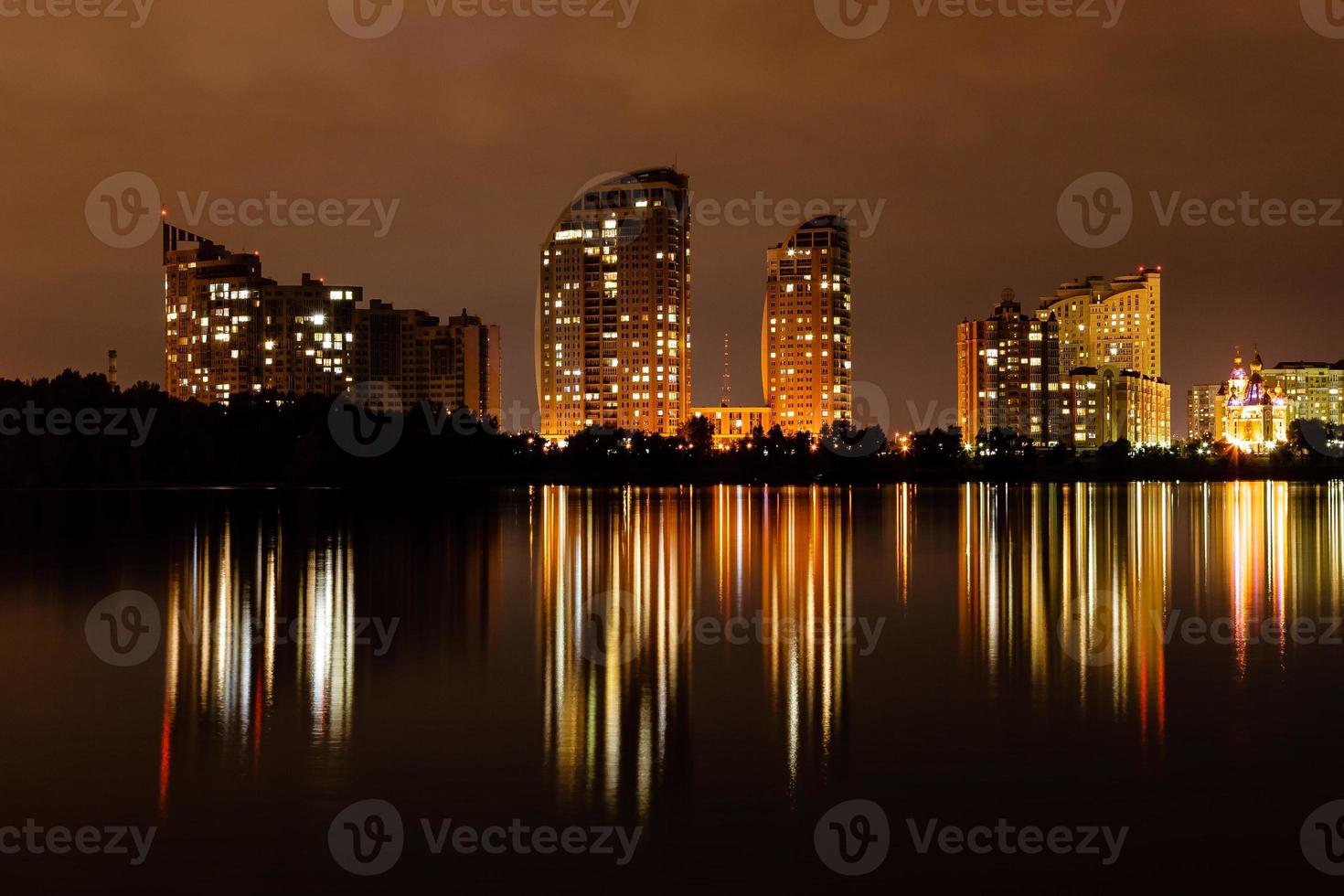 natt stad med reflexion av hus i de flod foto