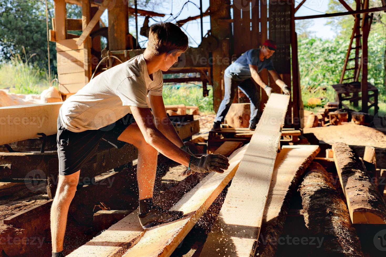 far och son arbetssätt tillsammans i en sågverk. foto
