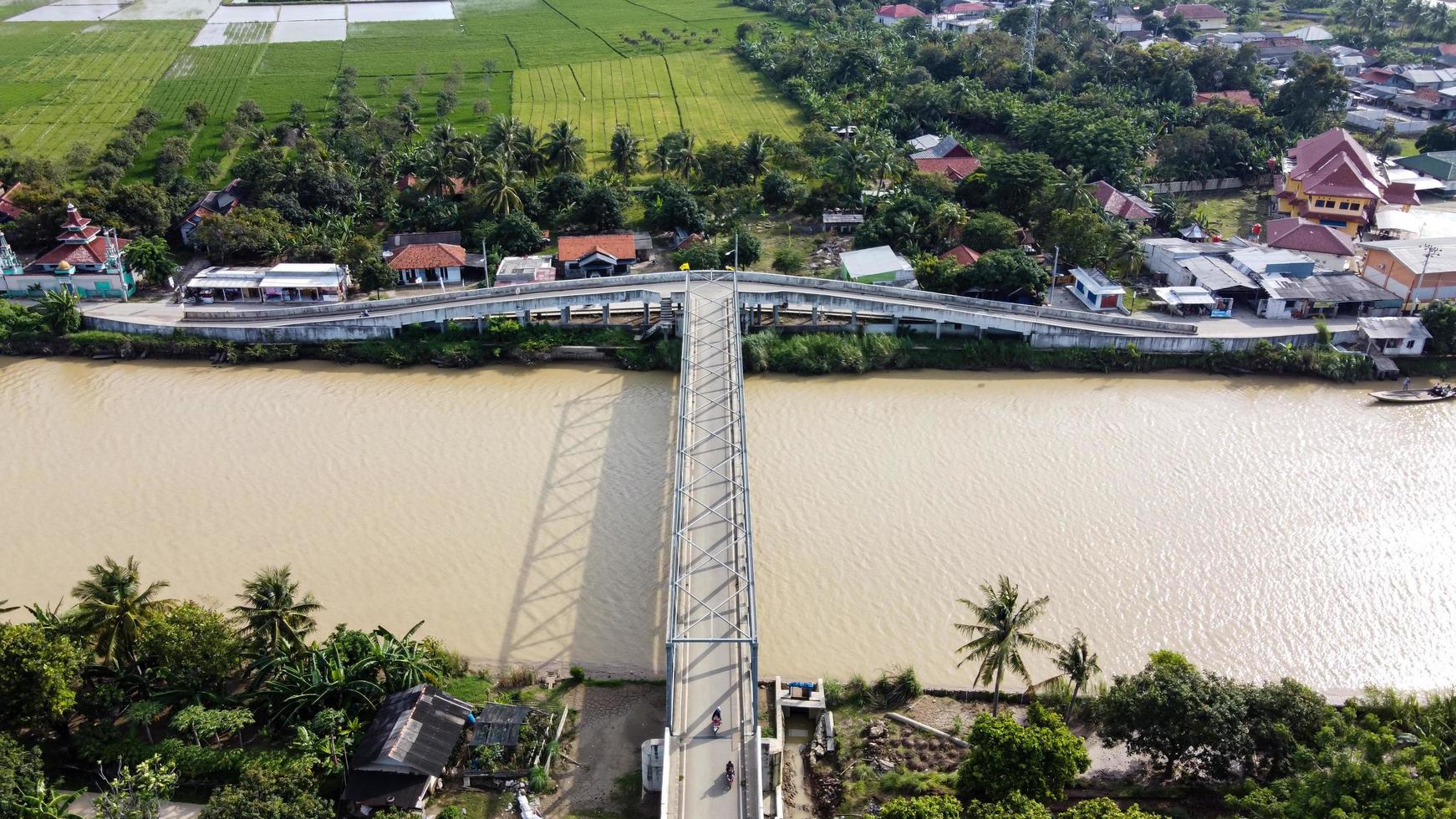 bekasi, Indonesien 2021 - Flygfoto över en lång bro till slutet av floden som förbinder två byar foto