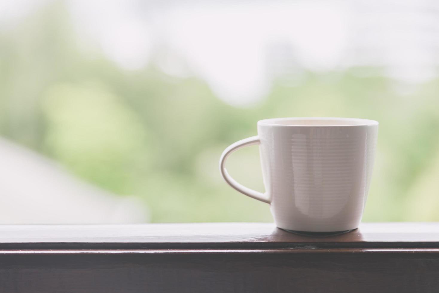 vit kaffekopp med utomhusvy - vintage filtereffekt foto