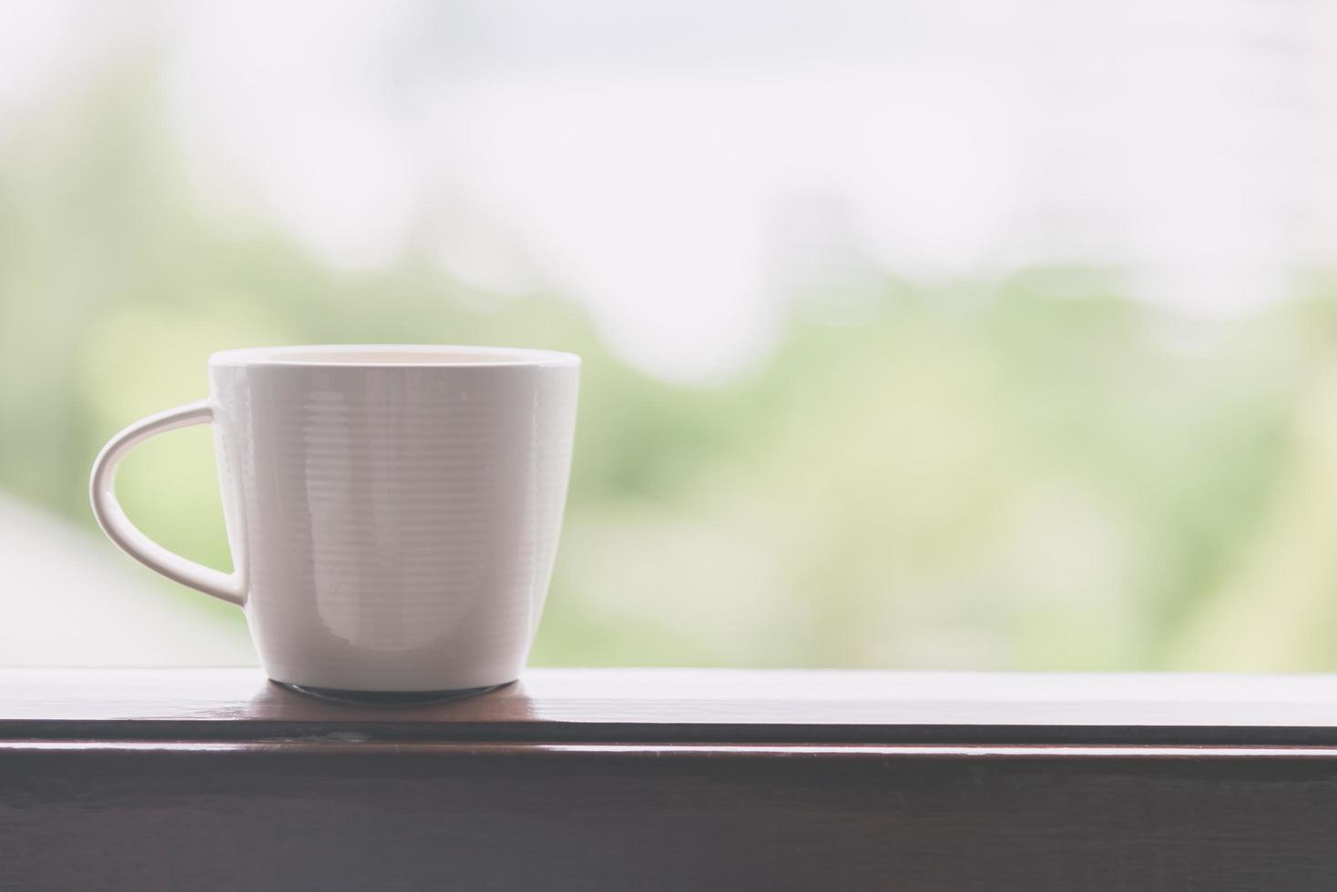 vit kaffekopp med utomhusvy - vintage filtereffekt foto