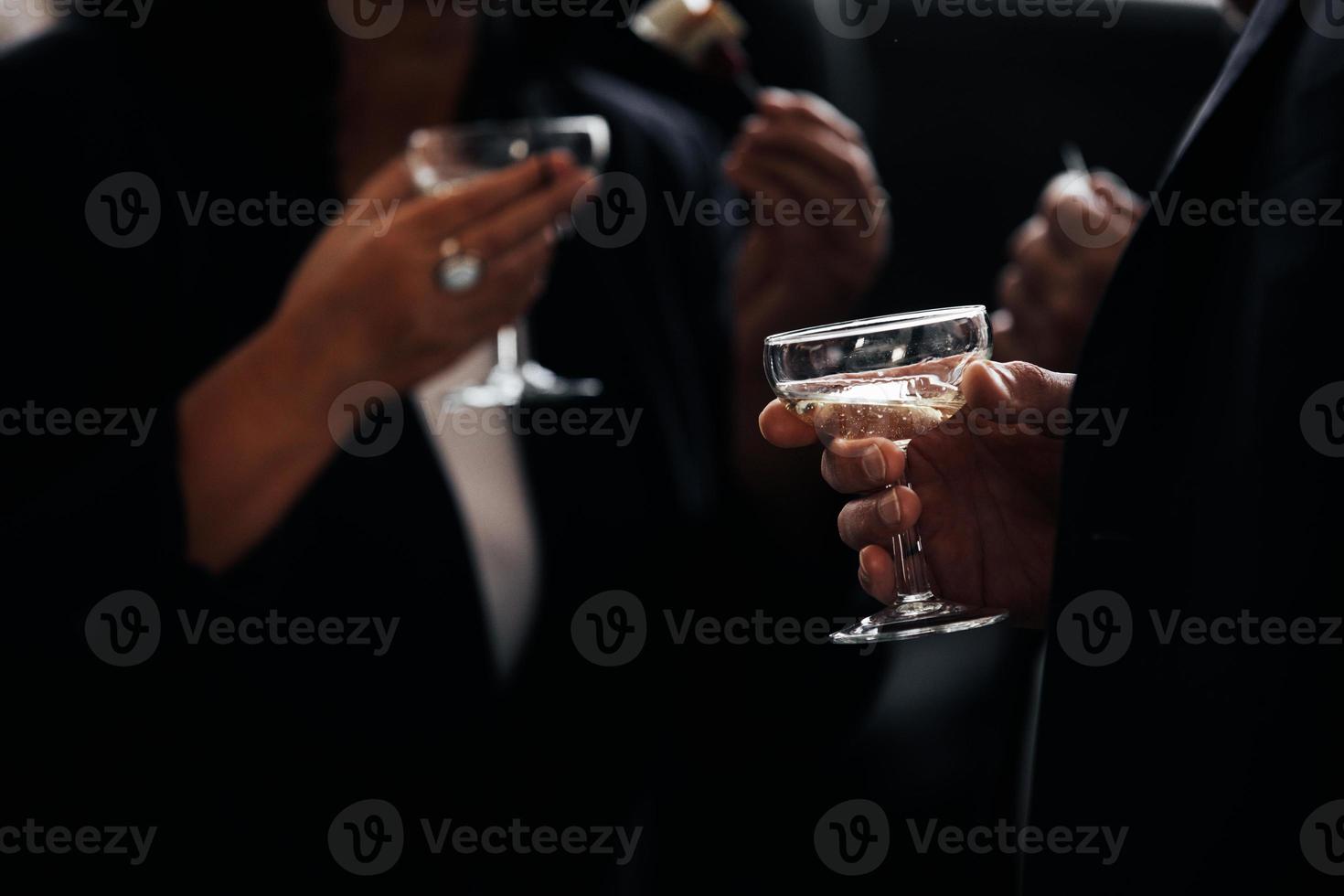 människor i snygga kostymer som håller glas champagne foto