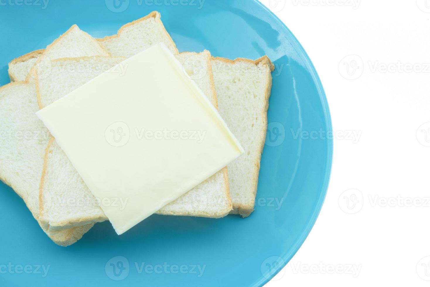 skiva av bröd med ost på blå tallrik med vit bakgrund foto