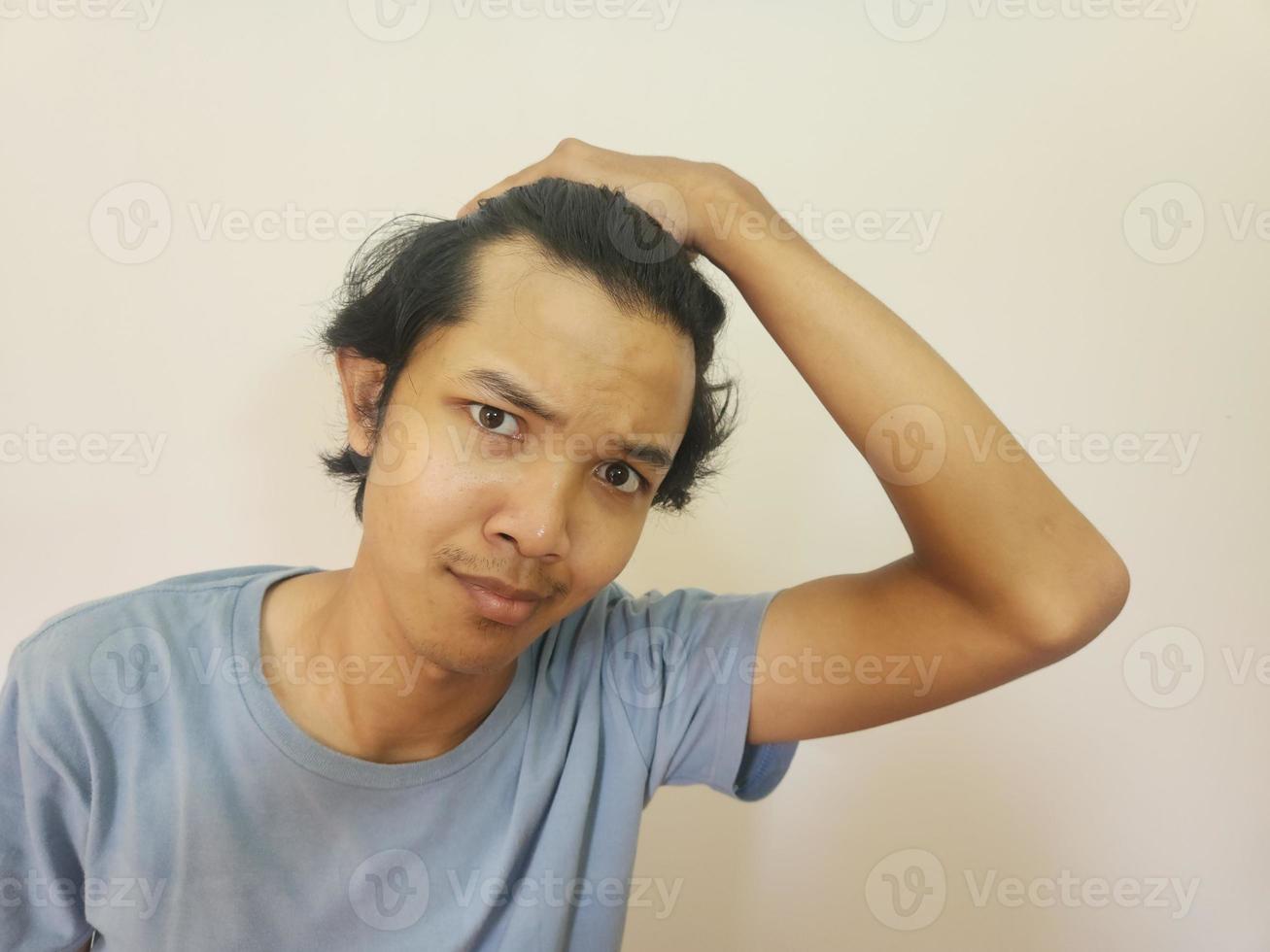 chockade ansikte av asiatisk man få skallig och förlorat hår i isolerat vit bakgrund foto