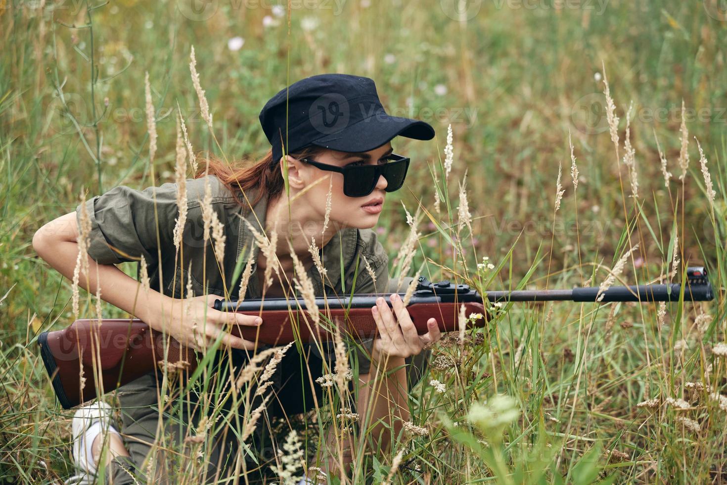 militär kvinna skydd med vapen i hand jakt färsk luft svart keps foto