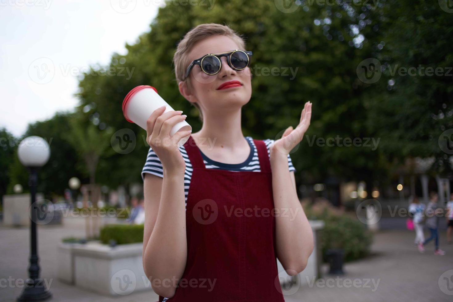 kvinna med kort hår på de gata bär solglasögon foto