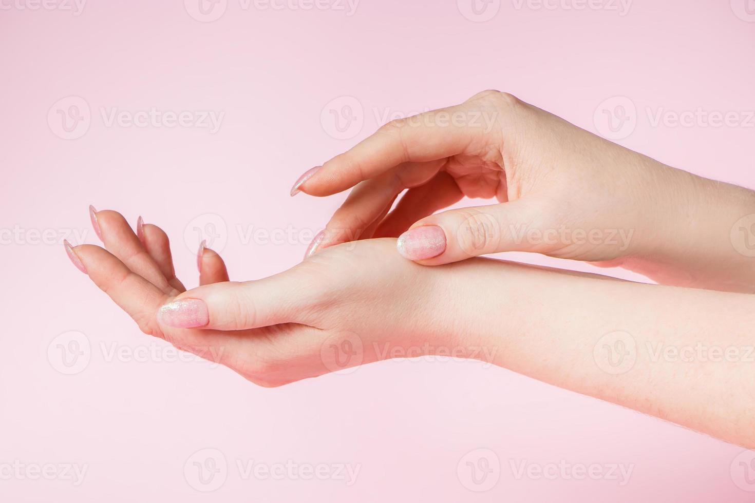 vackra kvinnliga händer på rosa bakgrund foto