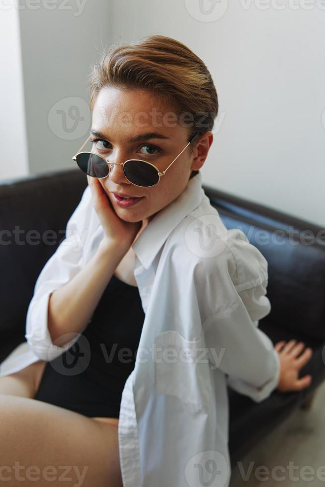 en kvinna liggande på de soffa med henne glasögon på och vridande foto