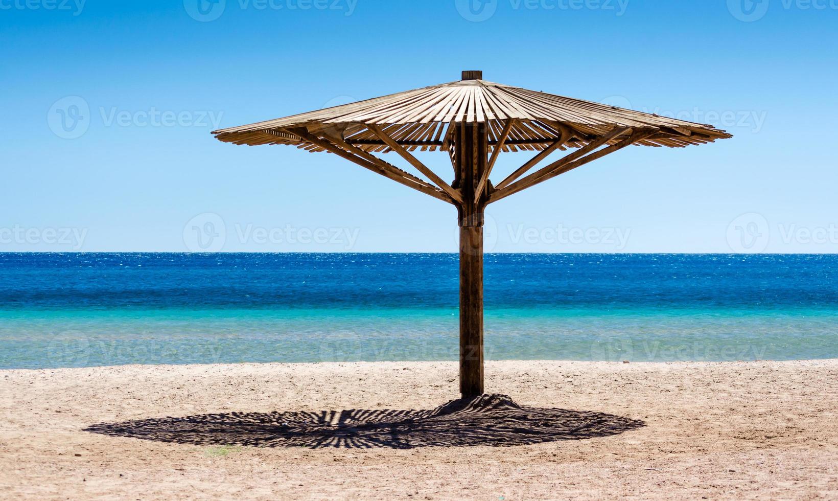 trä strandparaply på sanden foto