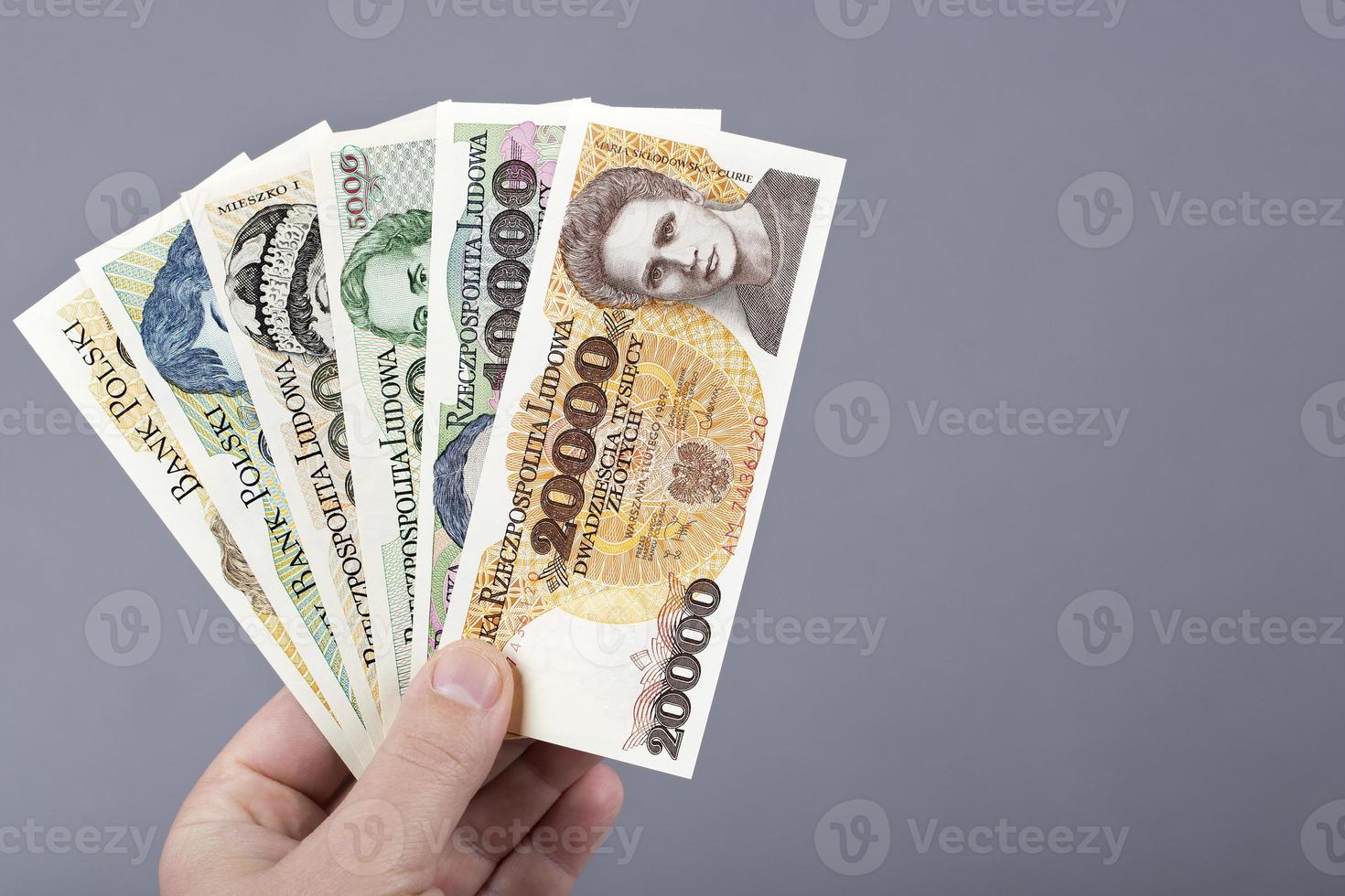 gammal putsa zloty i de hand på en grå bakgrund foto