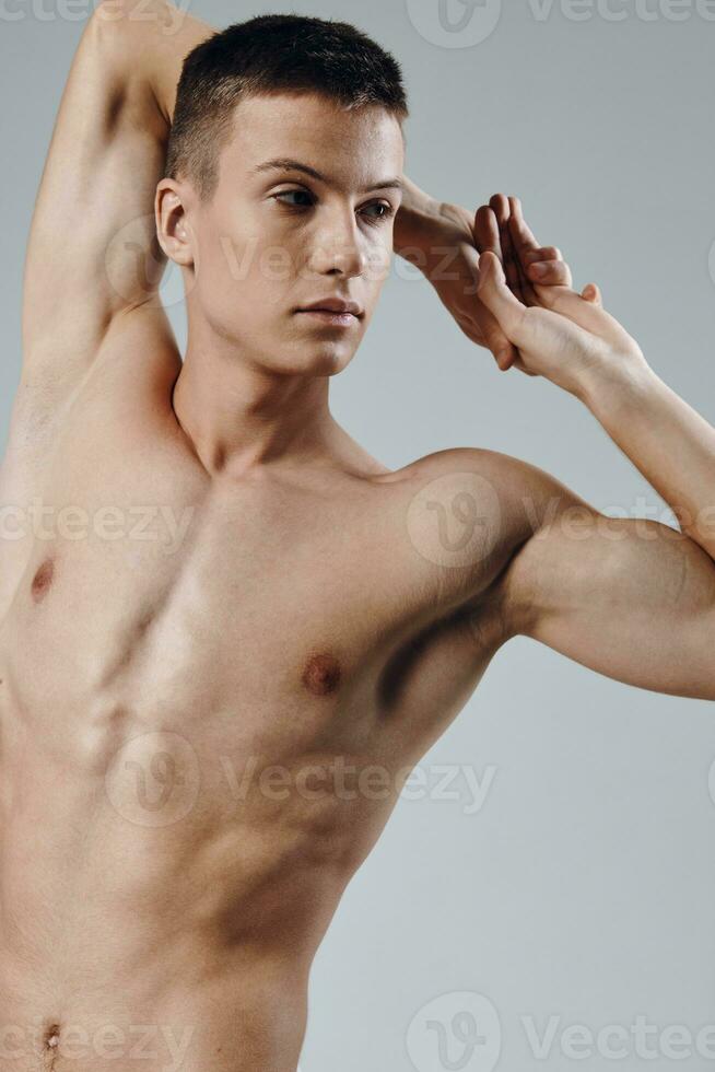 atletisk fysik ung manlig naken torso grå bakgrund porträtt beskurna se foto
