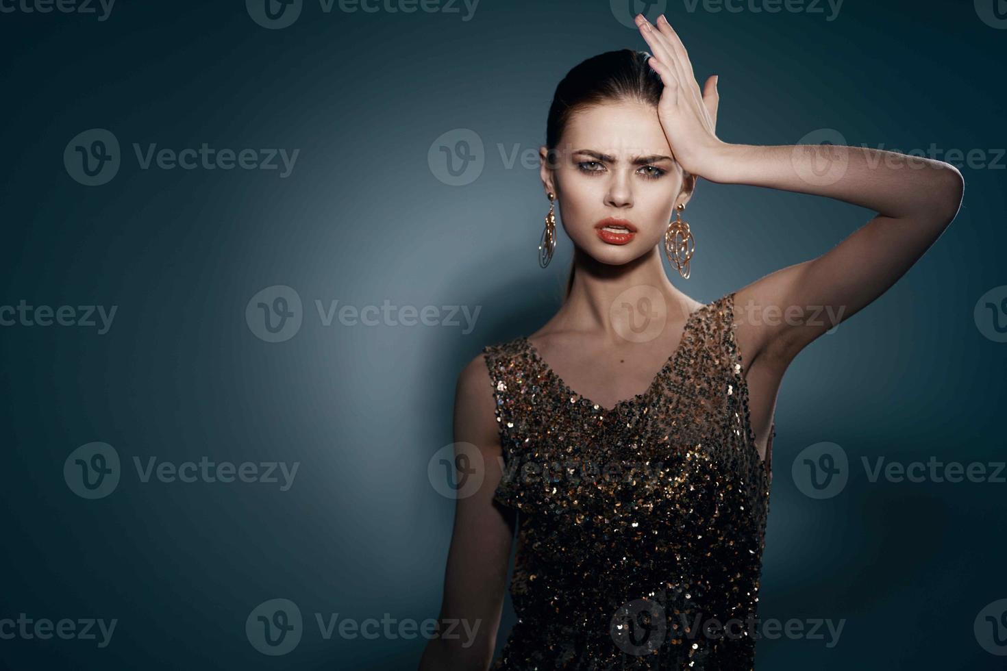 glad Söt kvinna på en gyllene klänning ljus smink studio lyx foto