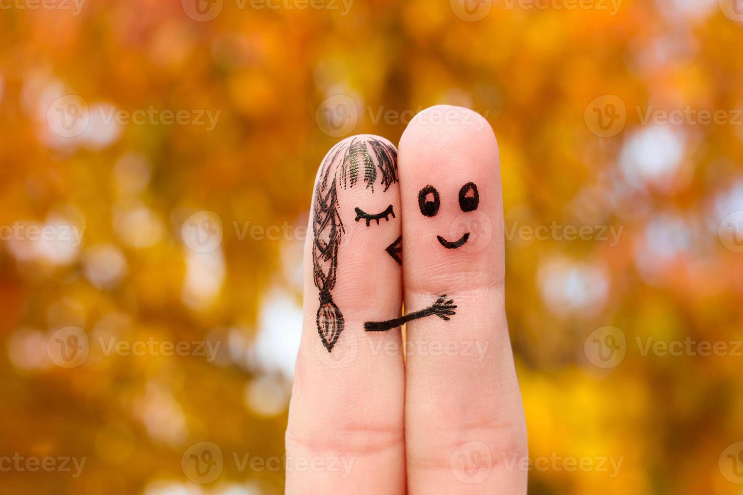 finger konst av en Lycklig par. flicka kyssar pojke på de kind. foto