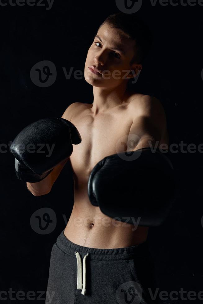 kroppsbyggare boxning handskar på svart bakgrund och grå byxor foto