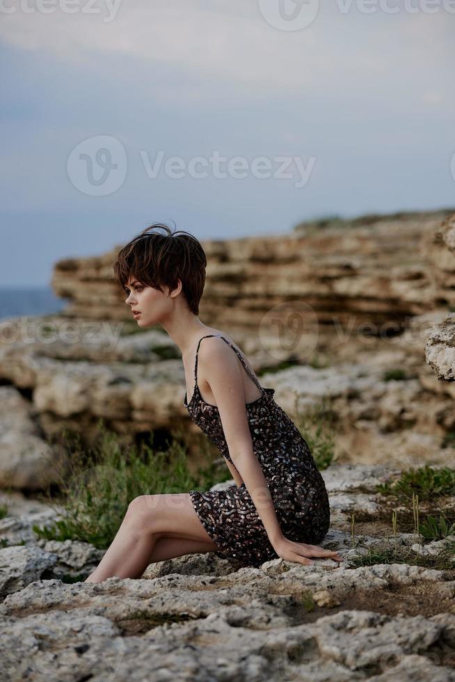 modern kvinna i klänning på natur stenar landskap livsstil foto