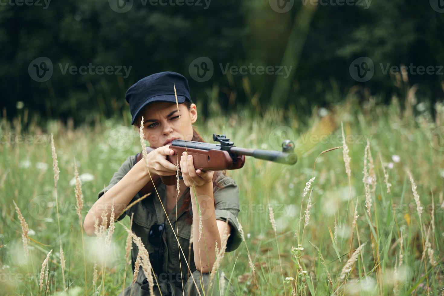 kvinna på utomhus- Sammanträde på de gräs vapen i de händer av en syn jakt färsk luft foto