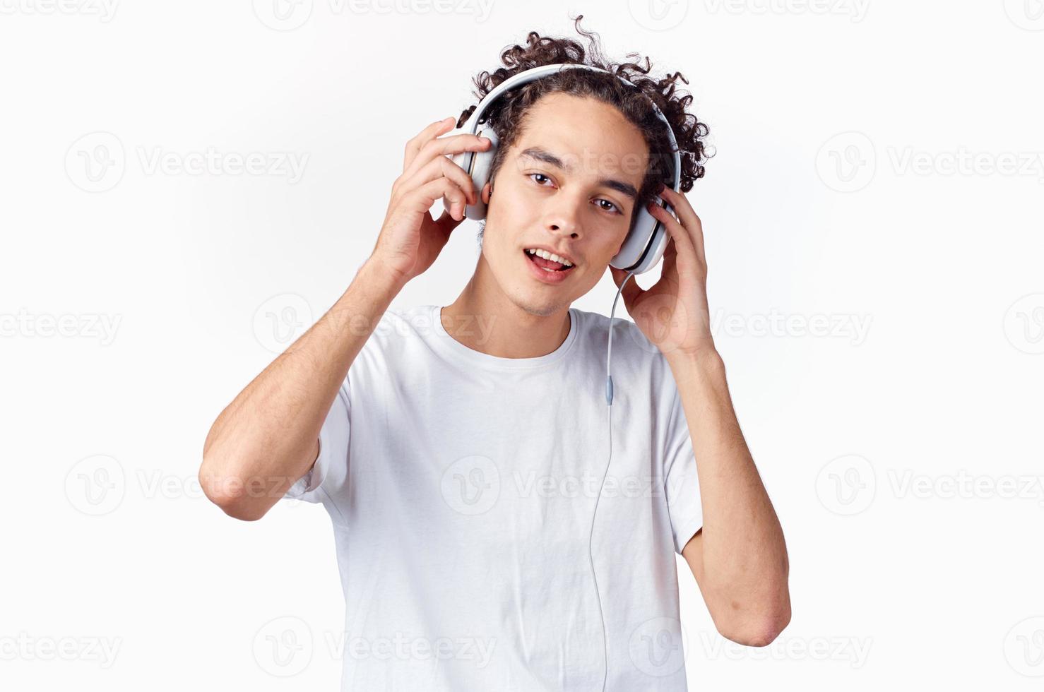 glad man med lockigt hår i hörlurar lyssnar till musik känslor foto