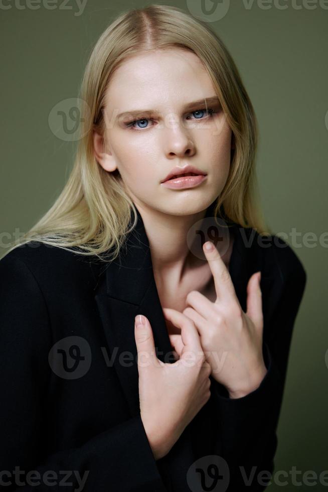 en stänga porträtt av en blond korsning henne vapen på henne bröst innehav en jacka förbi de krage foto