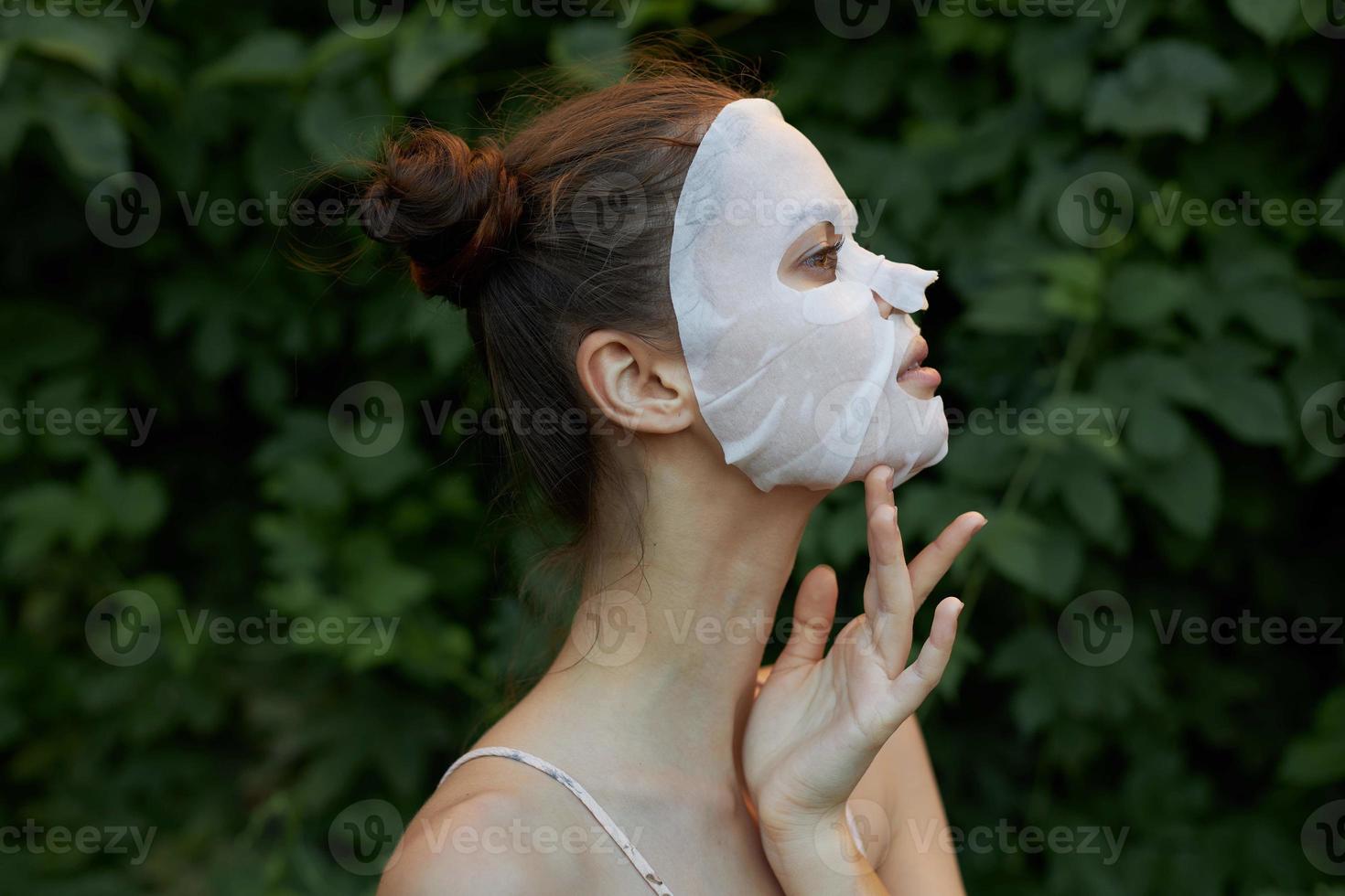 skön kvinna anti-åldring mask klar hud grön löv i de bakgrund foto