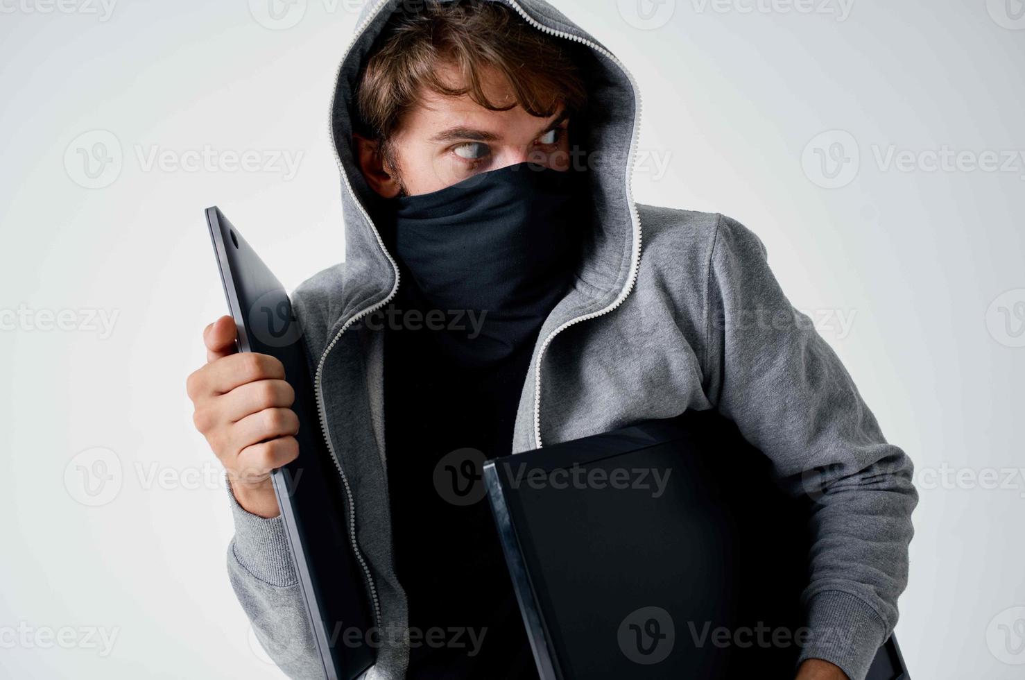 en man i en mask med en huva på hans huvud tjuv dataintrång foto