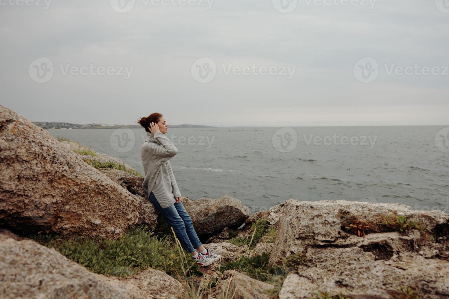 skön kvinna frihet promenad på de sten kust kvinna avkopplande foto