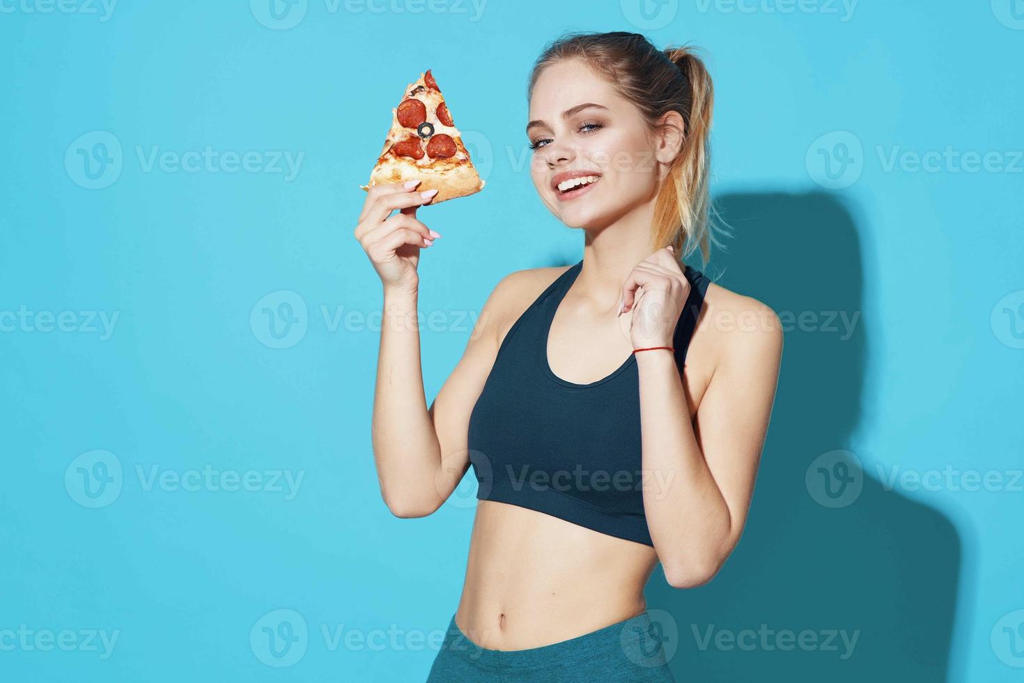 kvinna i sporter enhetlig äter pizza mat diet blå bakgrund foto