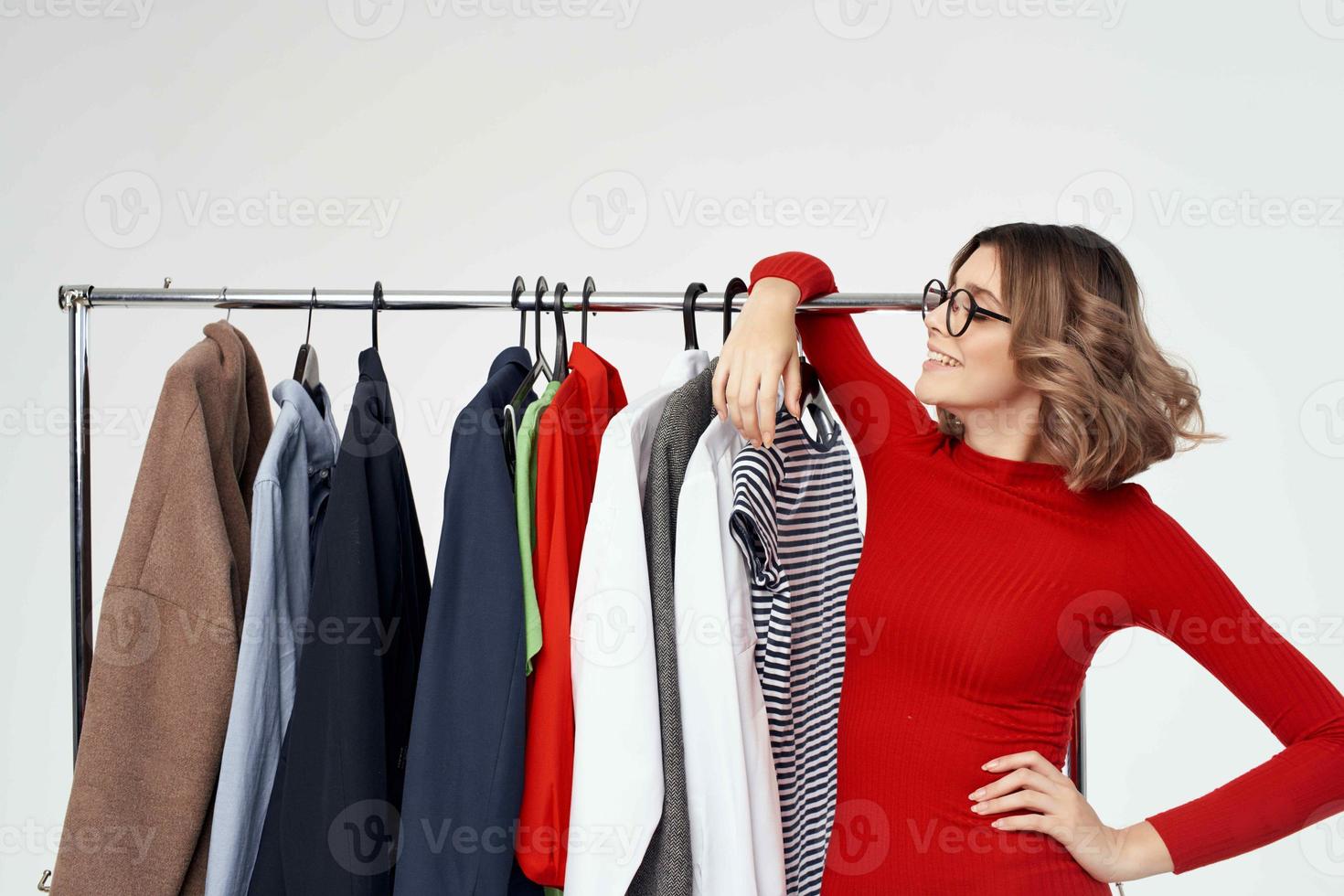 Söt kvinna med glasögon Nästa till kläder mode roligt isolerat bakgrund foto