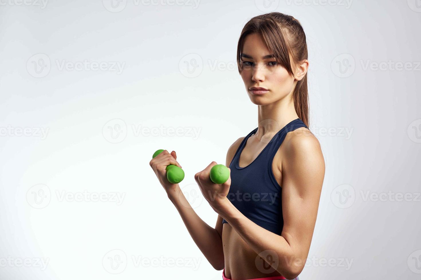 sportigt kvinna med hantlar i händer pumpade upp Tryck kondition övning Gym foto