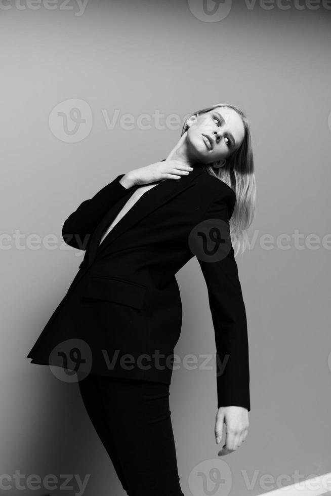 eleganta flicka finputsning henne nacke Framställ i de studio klädd i en klassisk kostym foto