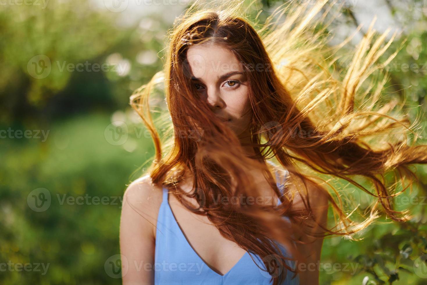 porträtt av en kvinna med lång flyg iväg hår röd hår i sommar, de begrepp av hälsa och vård för lång tjock hår skönhet foto